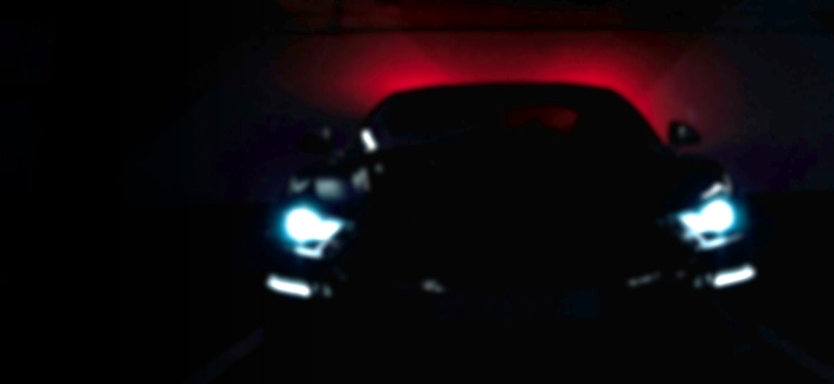 Dark performance car silhouette lit by a red glow in a garage - RO34 downpipes and performance exhaust